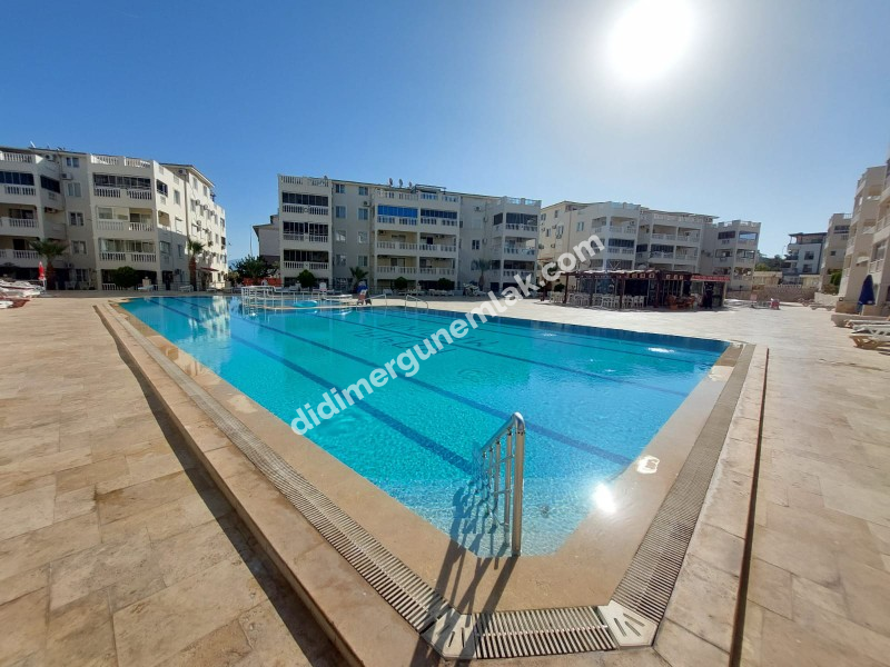 DİDİM ÇAMLIK MAHALLESİ’NDE,EŞYALI, HAVUZ CEPHELİ, DENİZE YÜRÜME MESAFESİNDE SATILIK 2+1 DAİRE