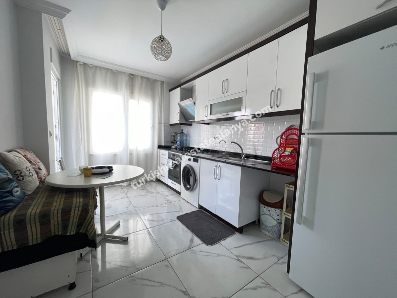 Na prodaju: potpuno namješten stan sa 3 spavaće sobe, 1 dnevnim boravkom i odvojenom kuhinjom, u samom centru Mahmutlara.