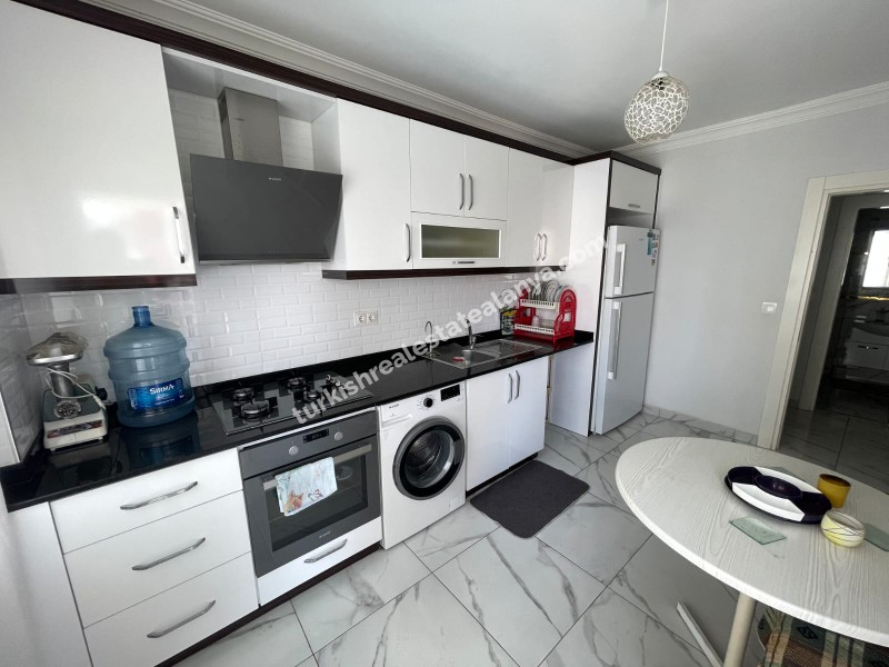 Na prodaju: potpuno namješten stan sa 3 spavaće sobe, 1 dnevnim boravkom i odvojenom kuhinjom, u samom centru Mahmutlara.