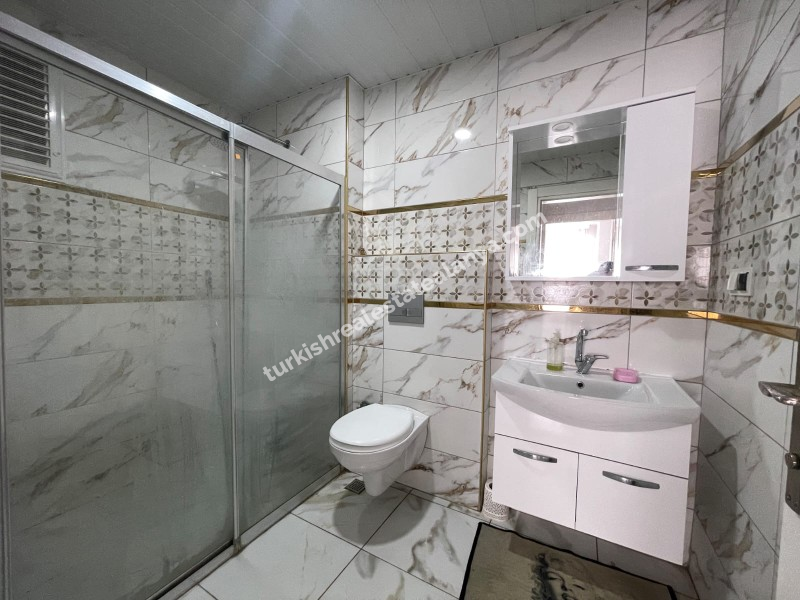 Na prodaju: potpuno namješten stan sa 3 spavaće sobe, 1 dnevnim boravkom i odvojenom kuhinjom, u samom centru Mahmutlara.